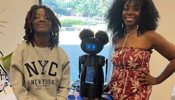 Professor Ruby Mendenhall and her mentee Jaimya Freeman with N1CØLE, wellness robot