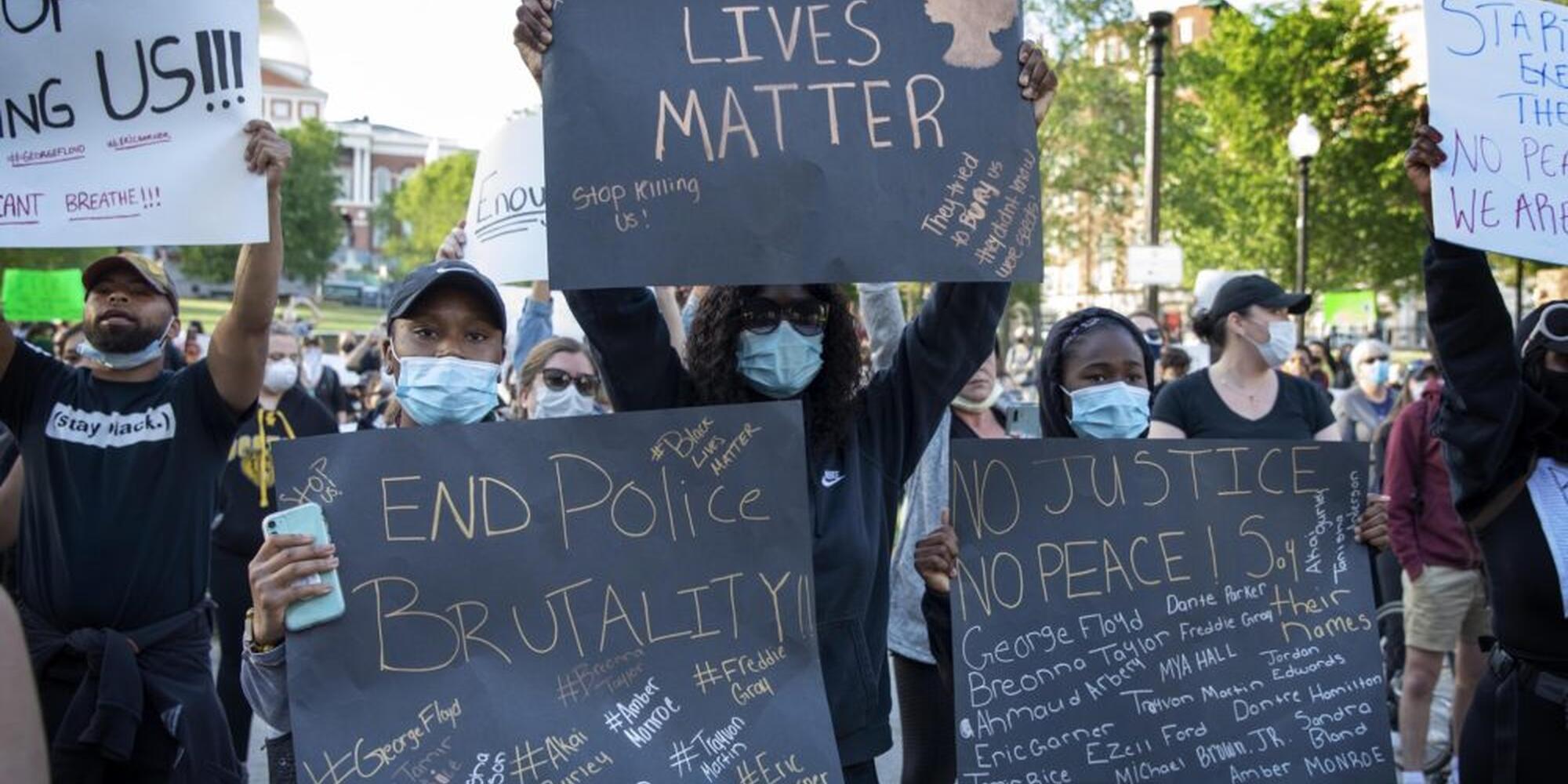 Image of BLM protesters with BLM signs held up