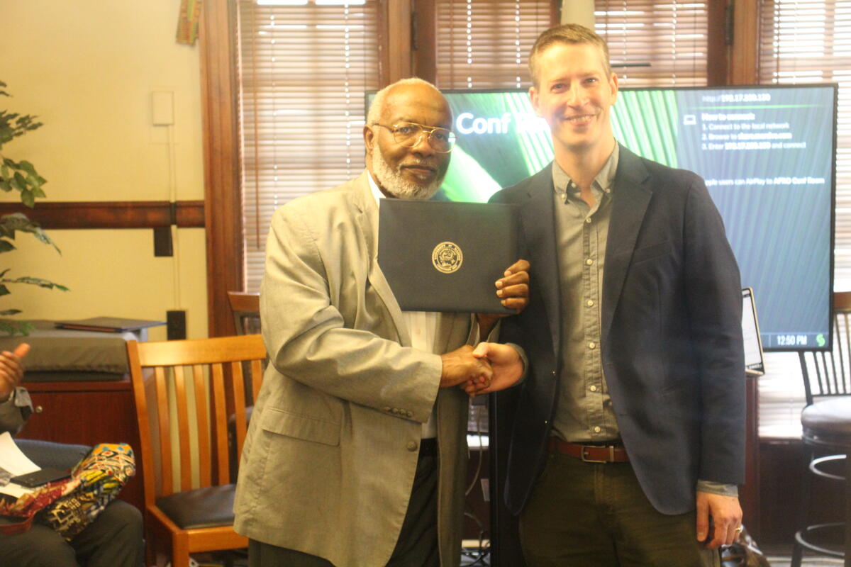 Professor Ronald Bailey holding his certificate award & Professor John Meyers 